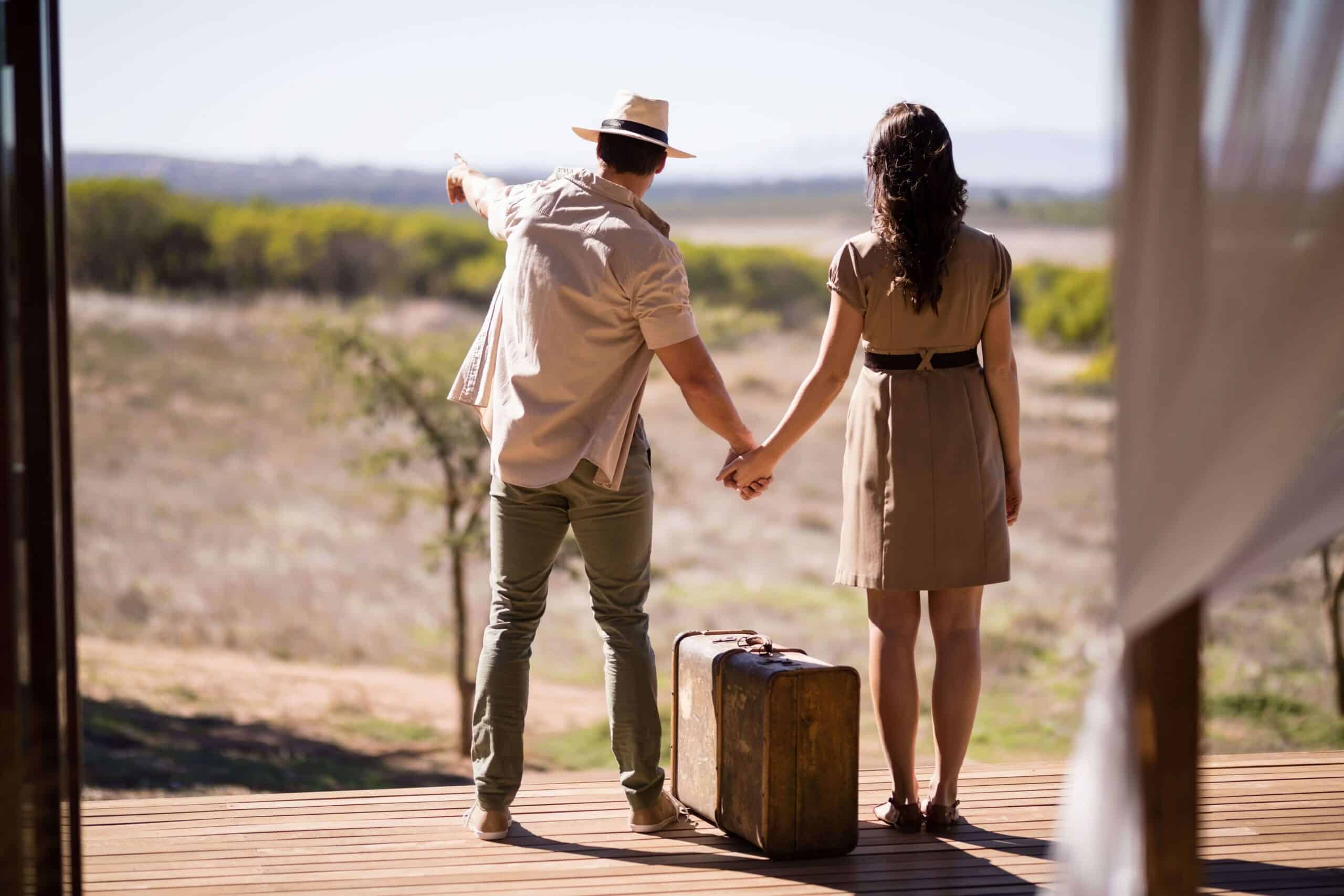 Couple on a Kruger safari package, holding hands outside a safari lodge