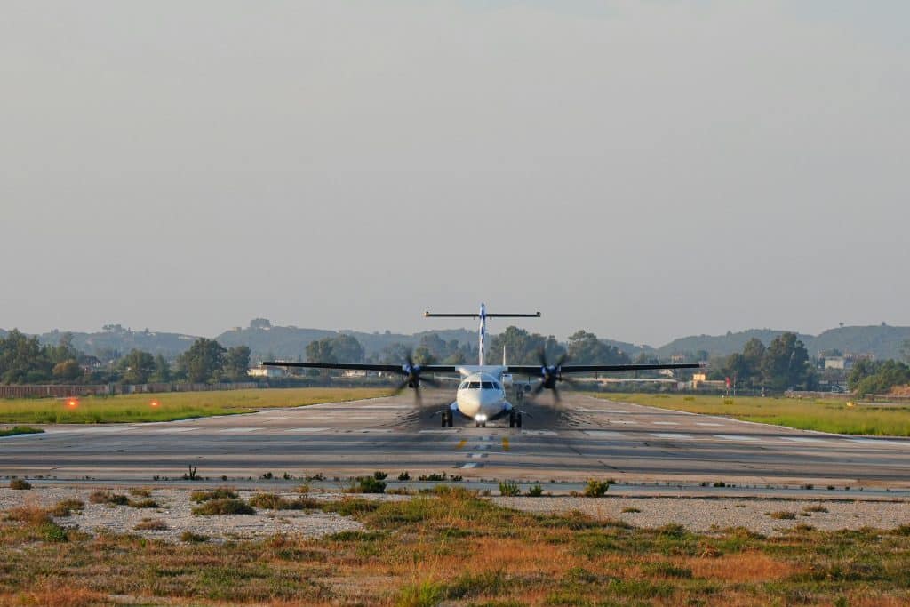 A front view of an aeroplane landing on a grassy runway as passengers fly to Kruger Park