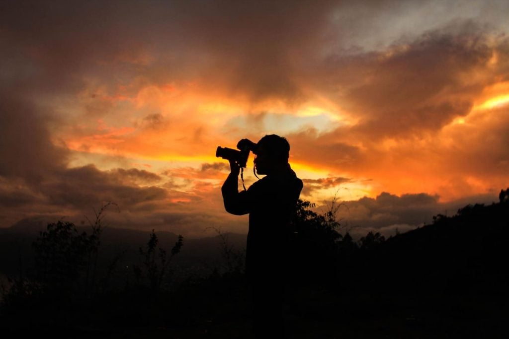 Silhouette of person photographing the sunset