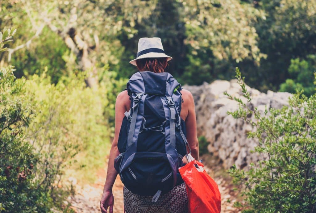 A woman walking with a backpack on a solo travel in Kruger Park adventure.