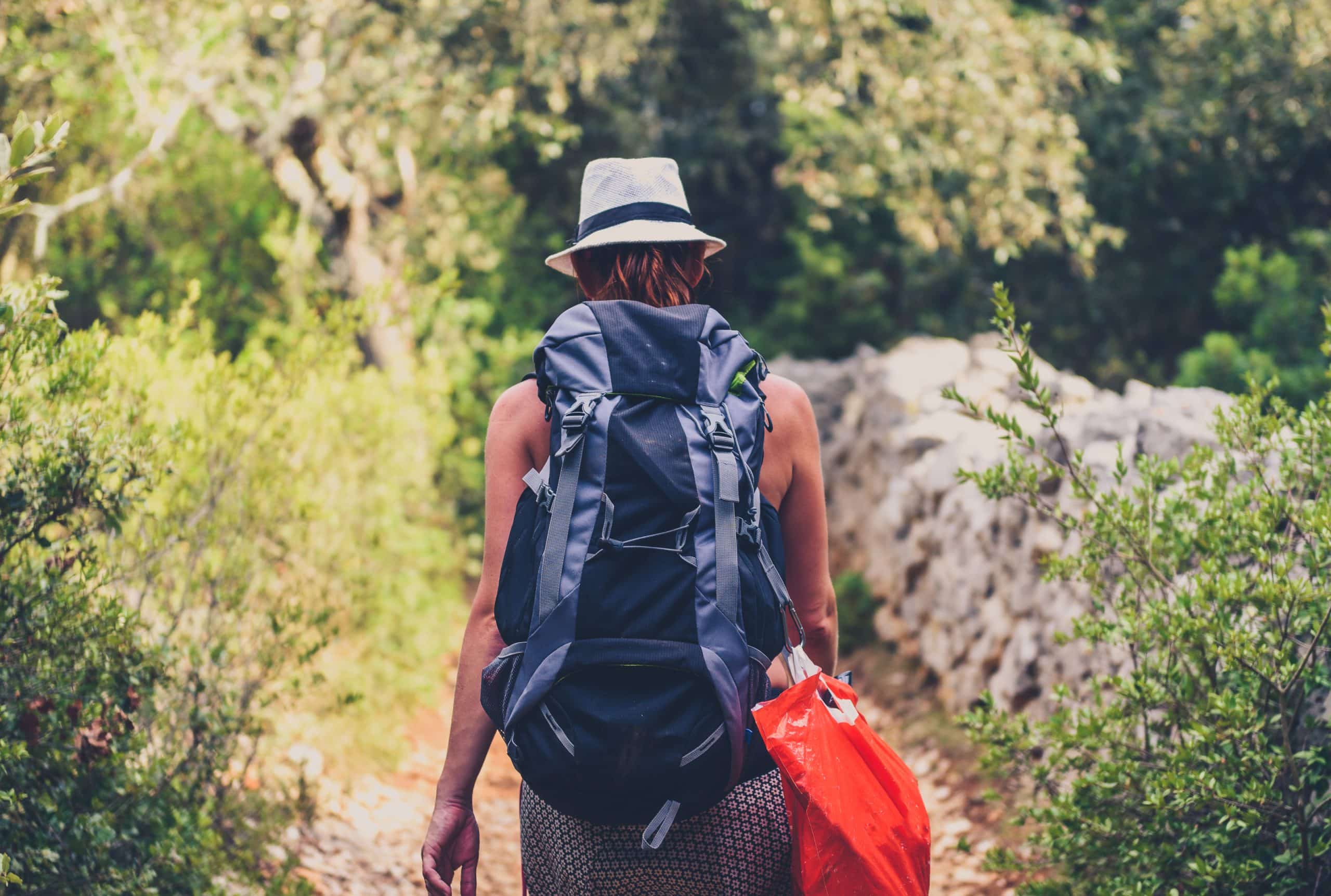 A woman walking with a backpack on a solo travel in Kruger Park adventure.