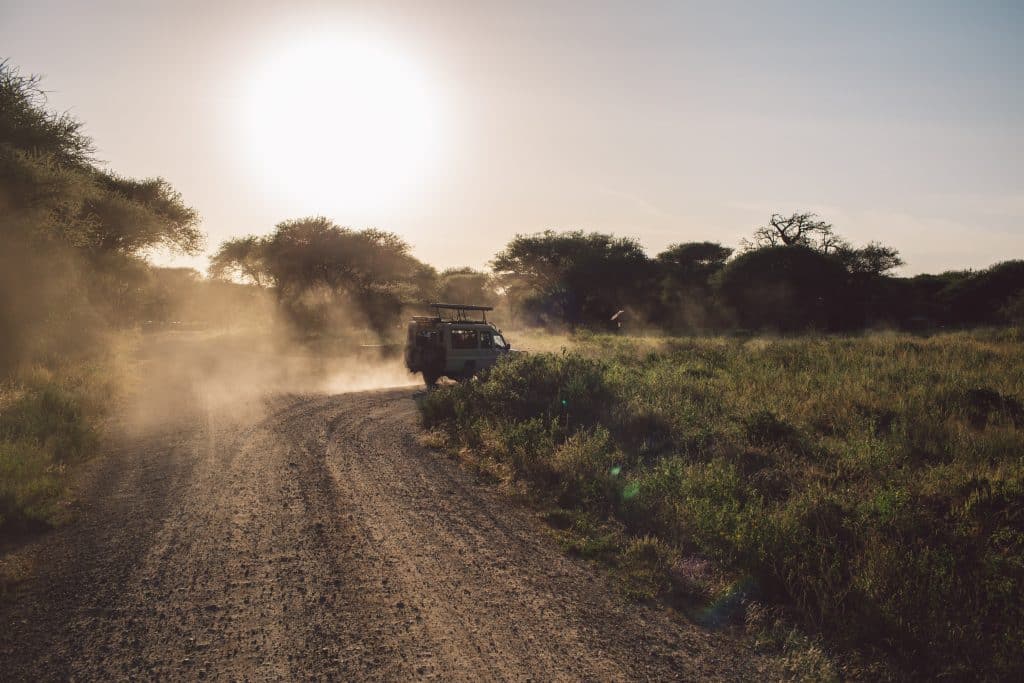An offroad vehicle following a Kruger Park regions guide into the sunset