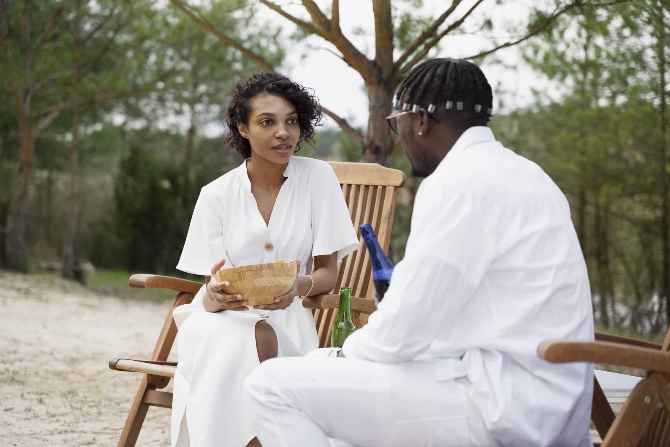 Couple relaxing outdoors in white outfits, enjoying a peaceful moment in nature for Bushveld Wellness Safari.