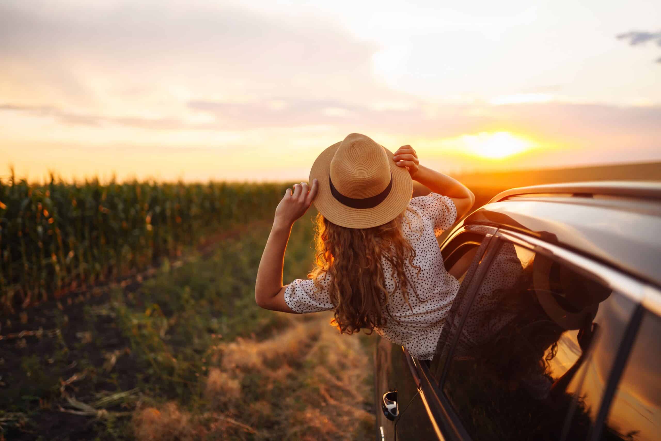 A young lady hanging out of a car’s passenger window on a Joburg to Kruger Park road trip