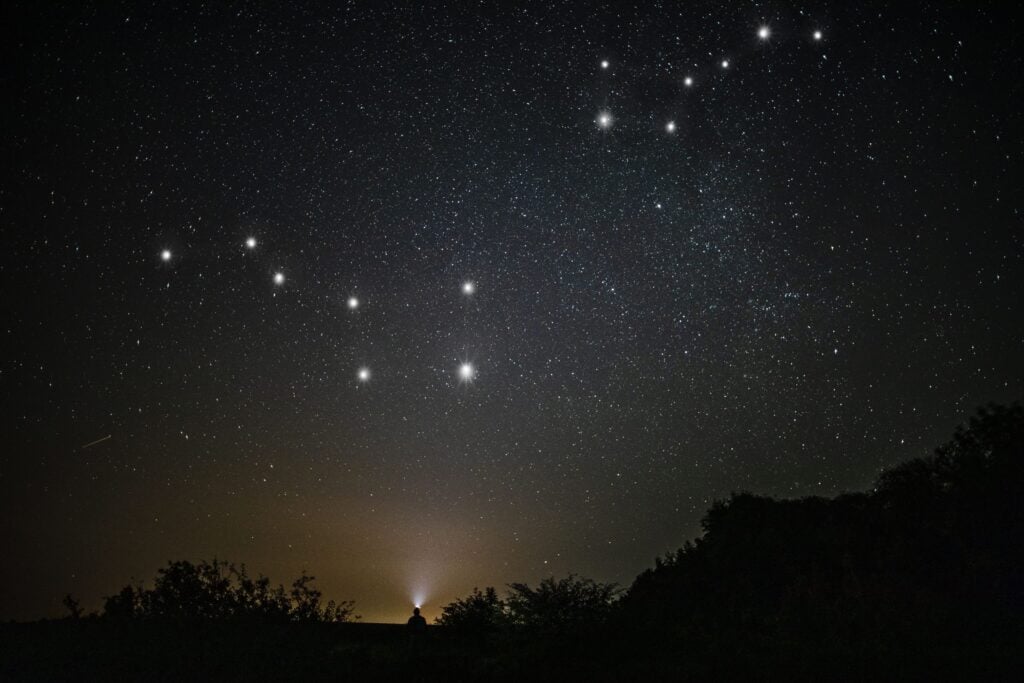 A man stargazing under a dark sky while participating in things to do in Kruger Park.