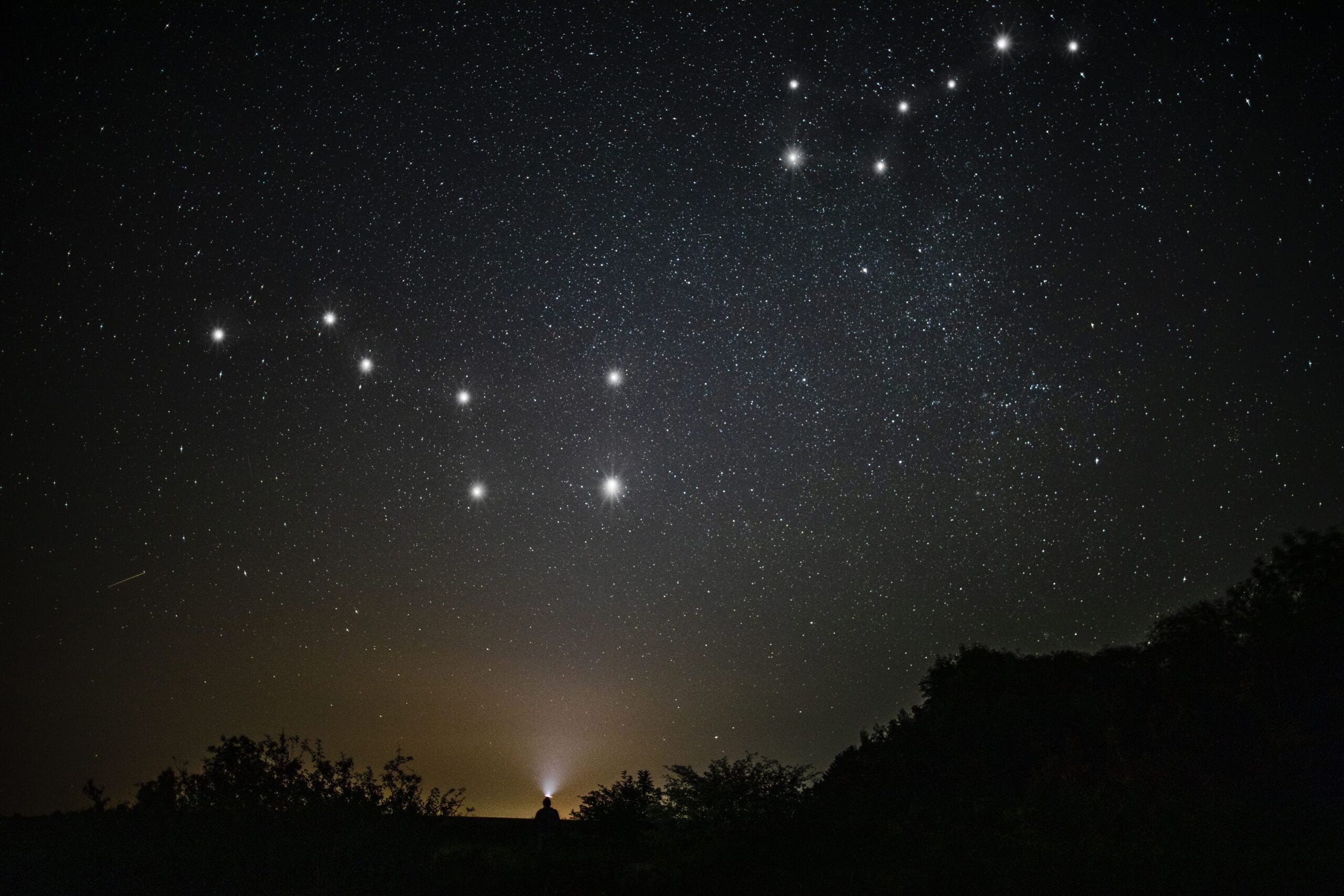A man stargazing under a dark sky while participating in things to do in Kruger Park.