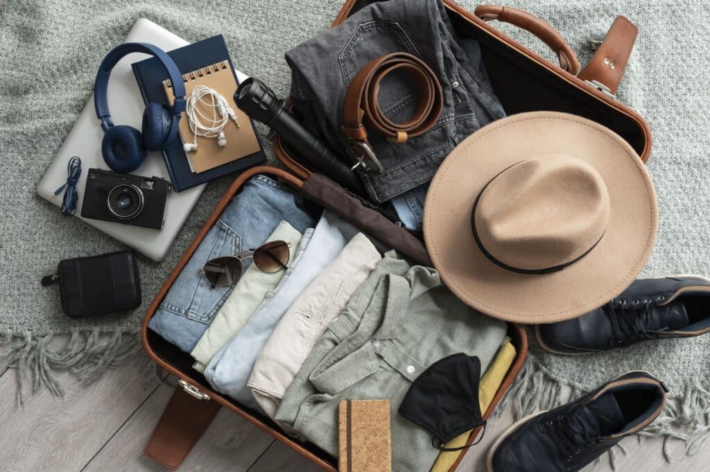 A closeup of clothing and travel items arranged in an open suitcase according to a safari packing list
