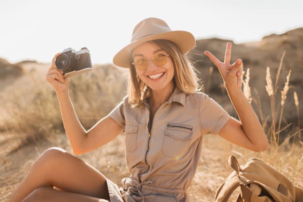 A young lady smiling and holding a camera on safari for Kruger Gate Hotel reviews
