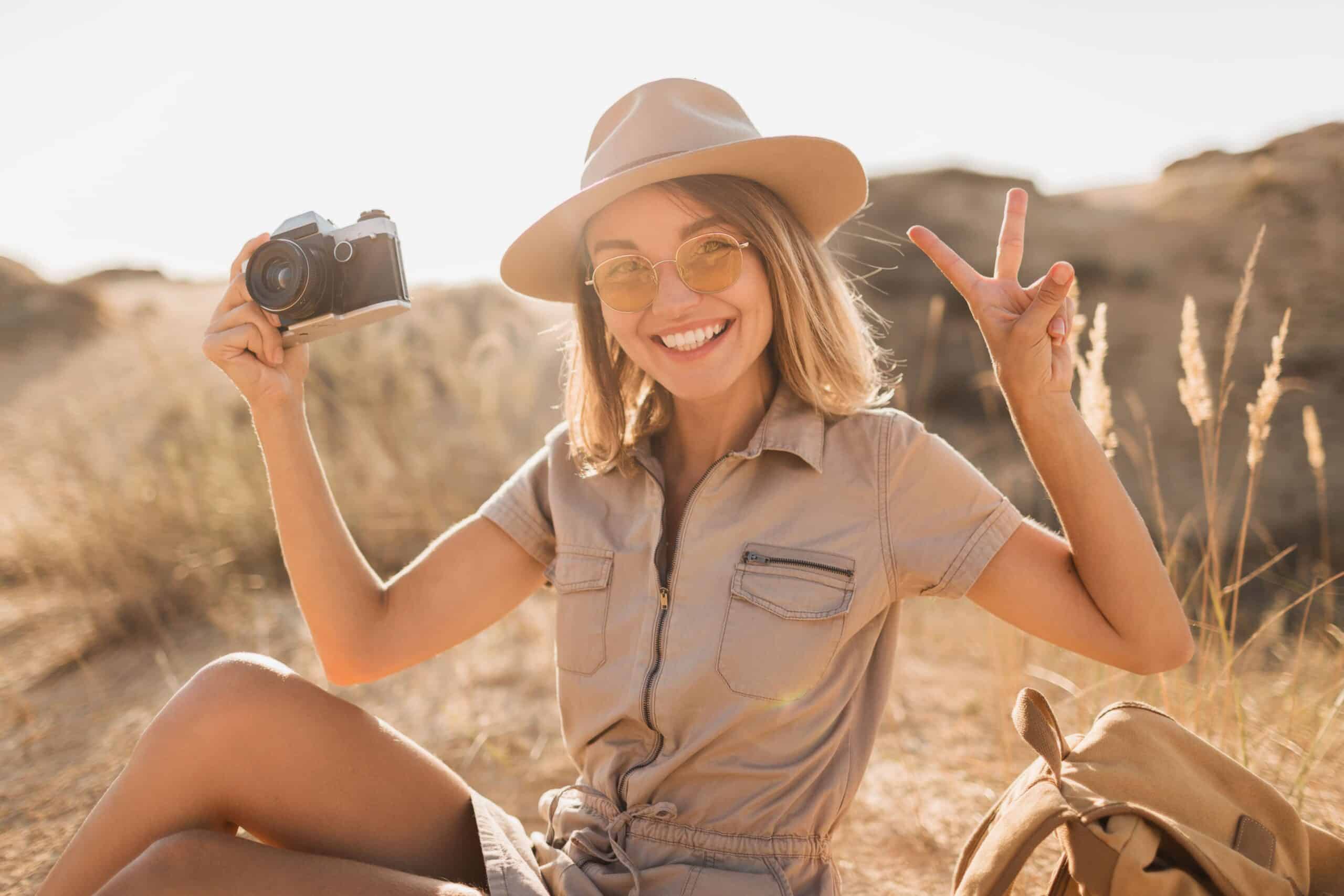 A young lady smiling and holding a camera on safari for Kruger Gate Hotel reviews