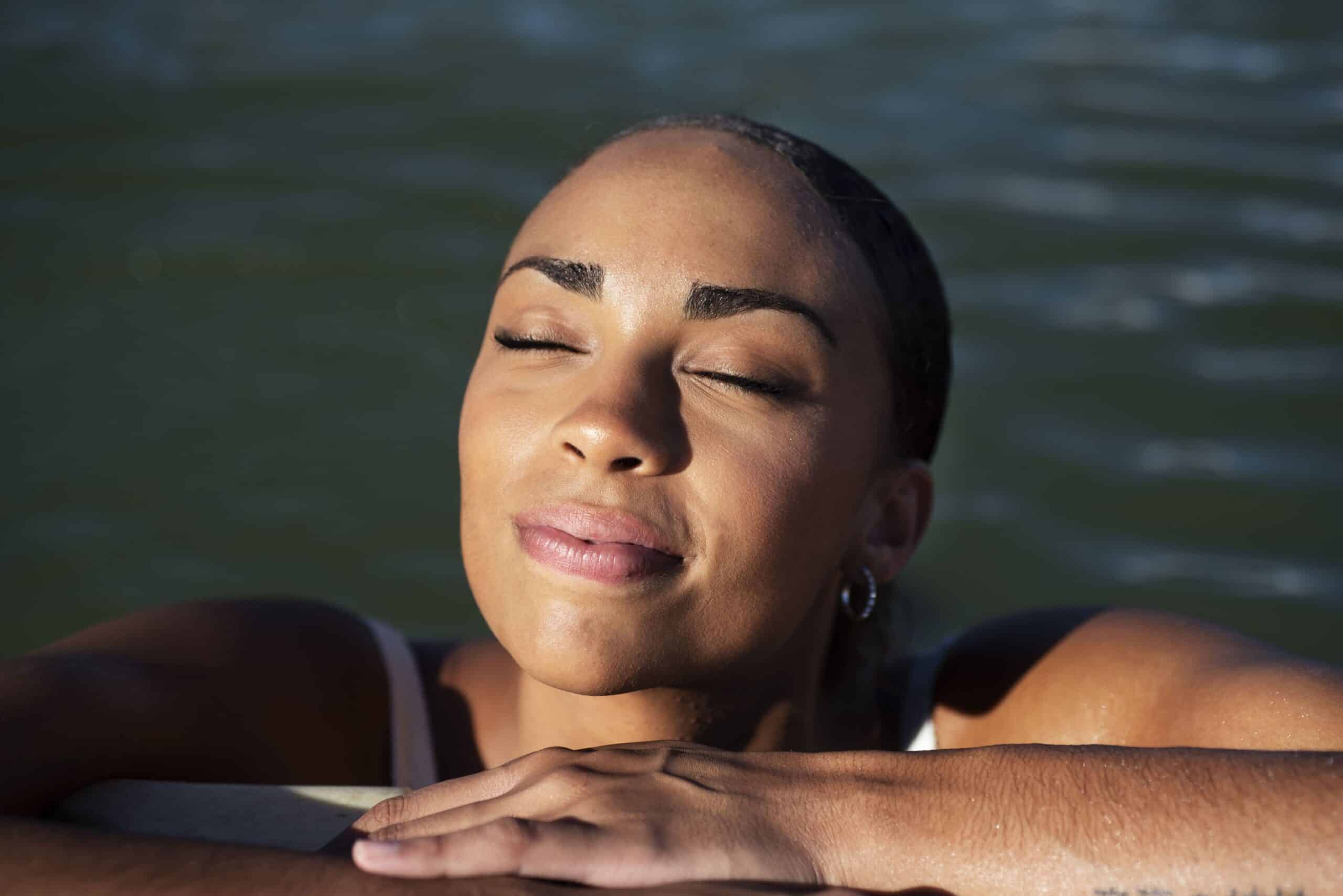 A woman basking in the sun from a swimming pool while holidaying at self-catering accommodation